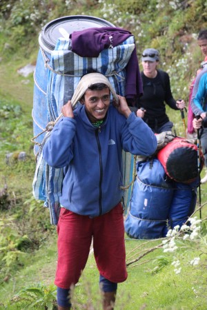 Porters carry gear into the Tamur River