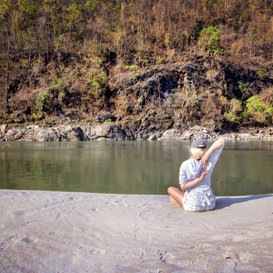 Image of lady stretching on beach on Karnali River in Nepal