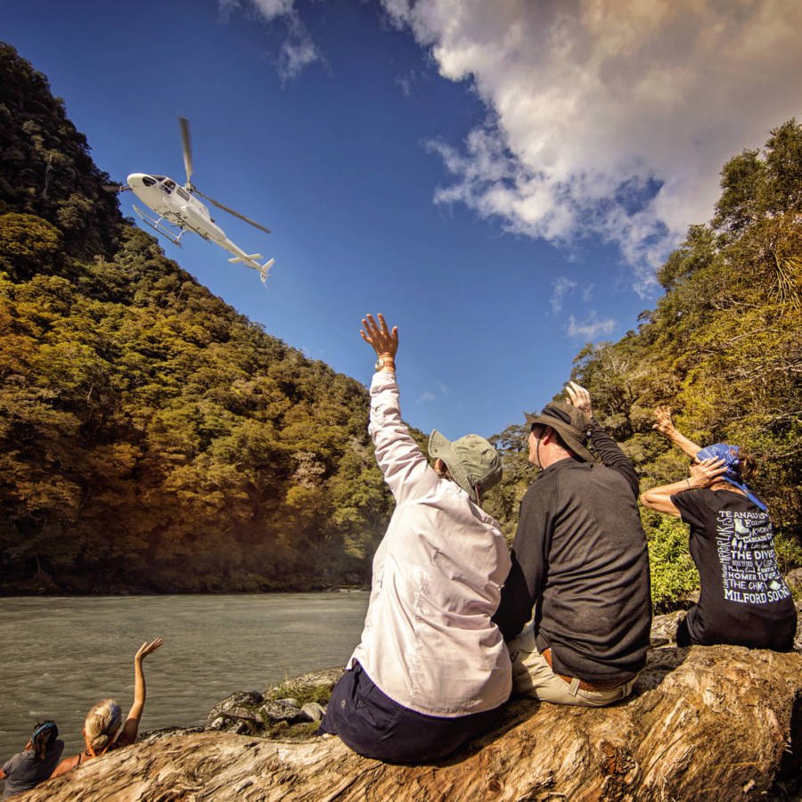 Image of helicopter flying over people who are waving