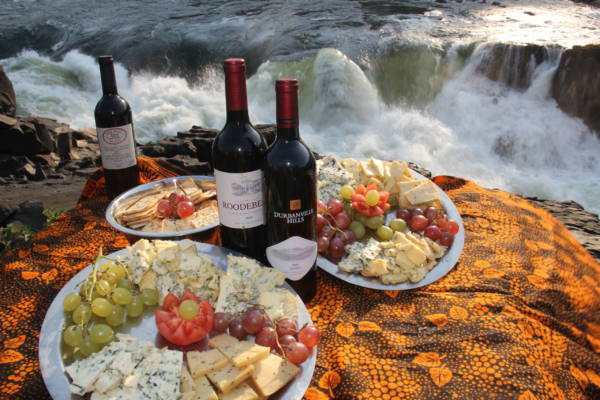 Image of wine and cheese board overlooking Moemba Falls, Zambezi River