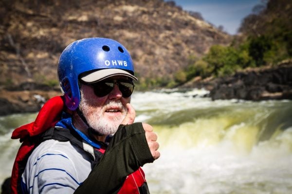Older man white water rafting as a solo adventure traveller