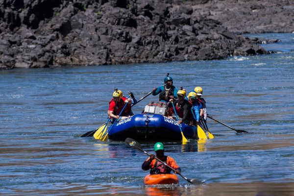 raft paddling on the Zambezi with safety kayaker