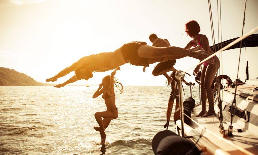 People jumping in fun off a yacht