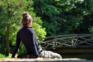 Beat the post holiday blues by taking a mindful moment. Girl looking at a bridge in a peaceful wood