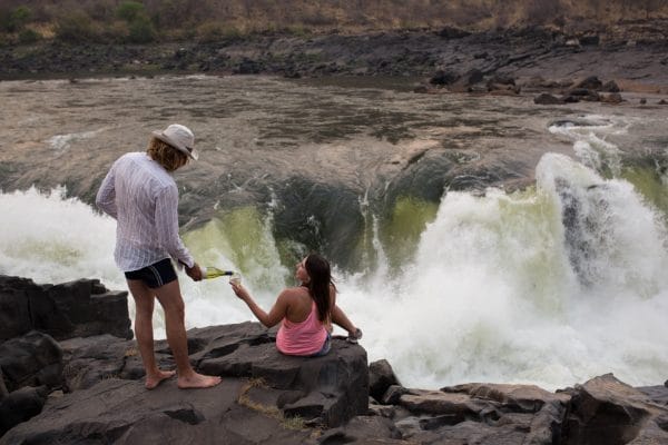 Guide pouring client glass of wine on the Zambezi